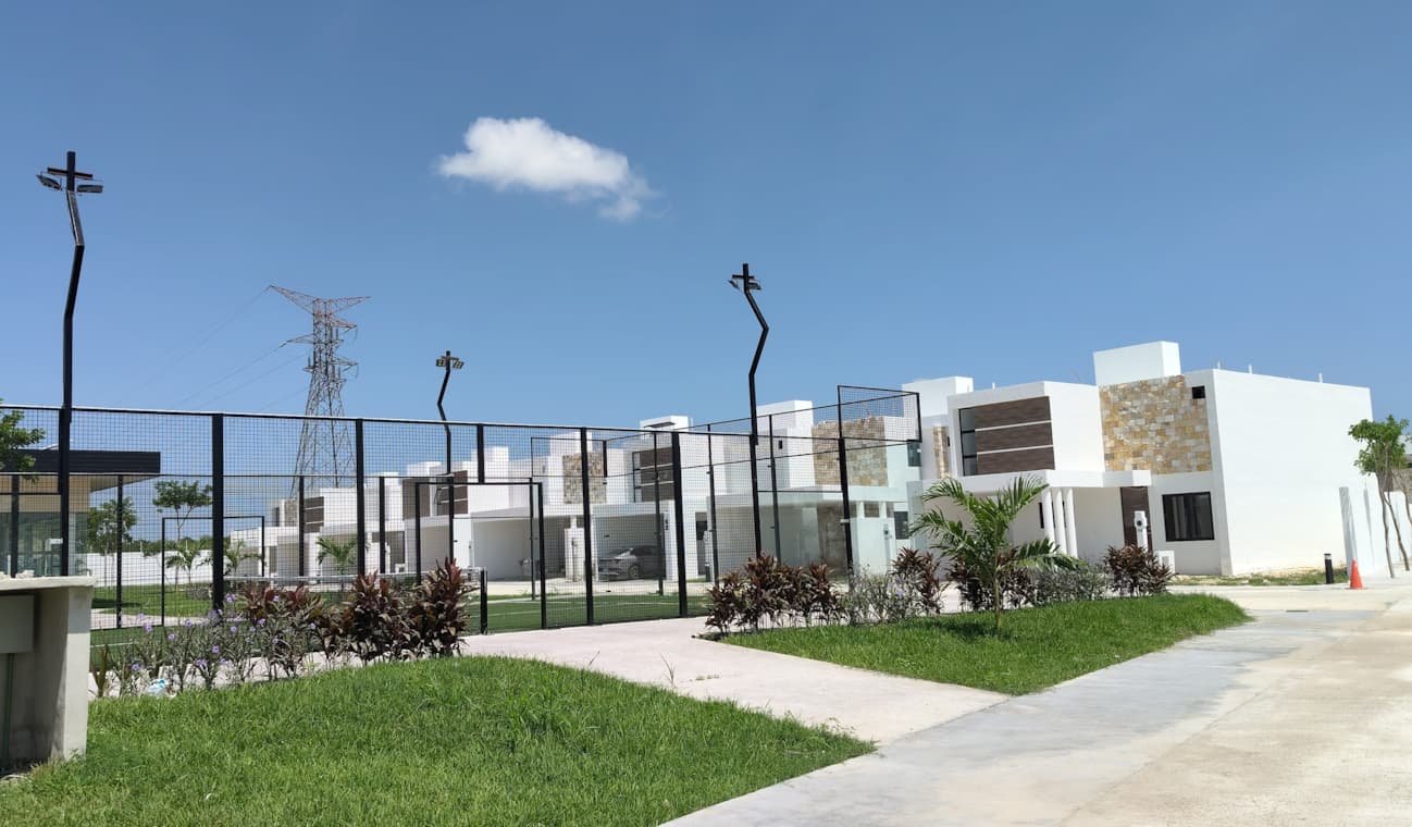 Residencias de Adara detrás de la reja perimetral, con jardines y áreas verdes