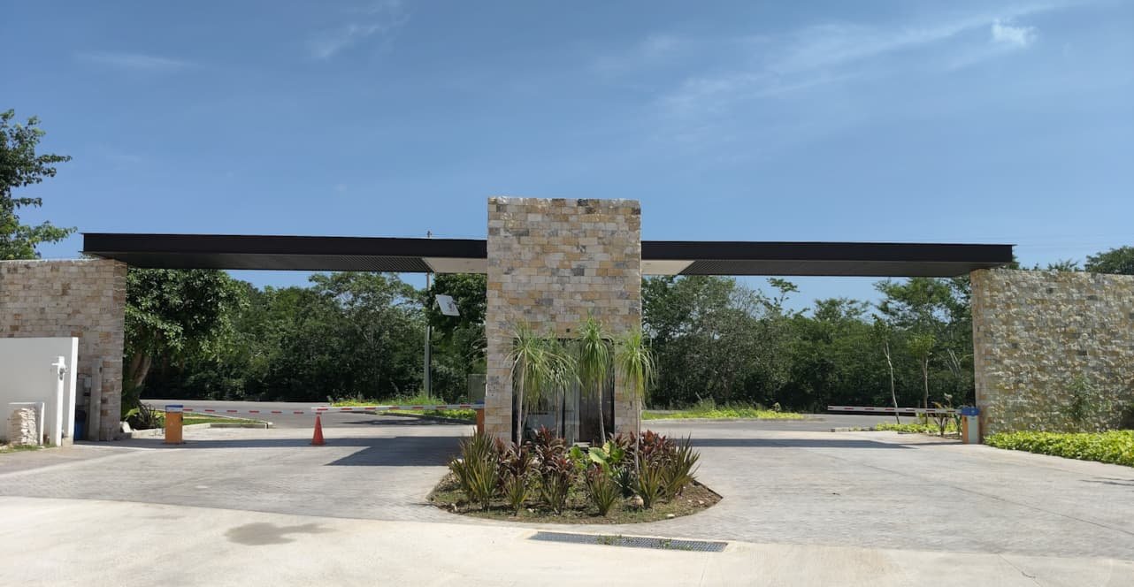 Pórtico de acceso de Adara visto de frente, con muros de piedra y jardinera central